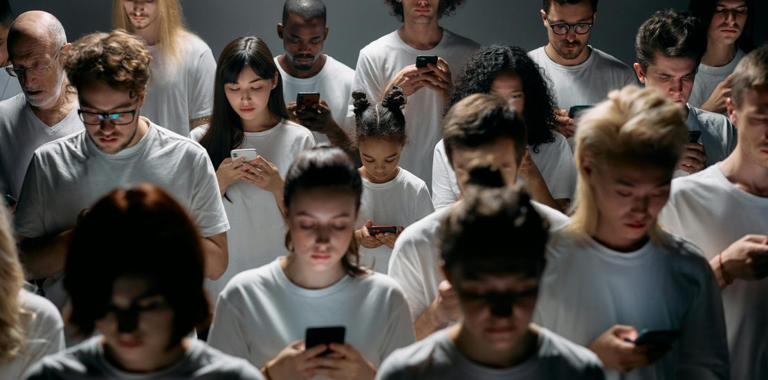 Group-of-people-all-staring-at-their-phones. Light-from-screen-illuminating-faces.
